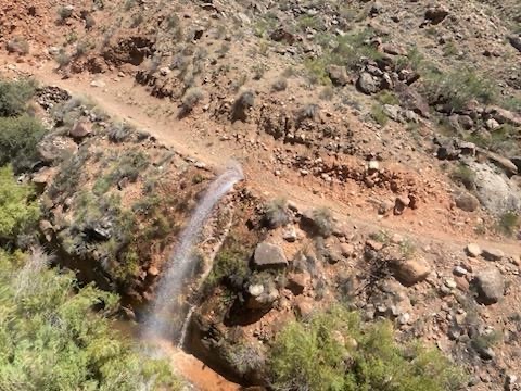 A gush of water expands 20 feet from a trail in the inner canyon