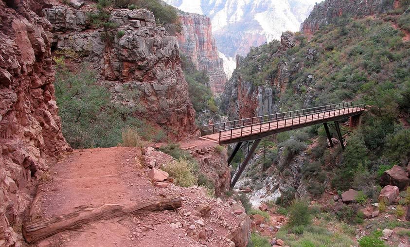 A footbridge spans across a canyon