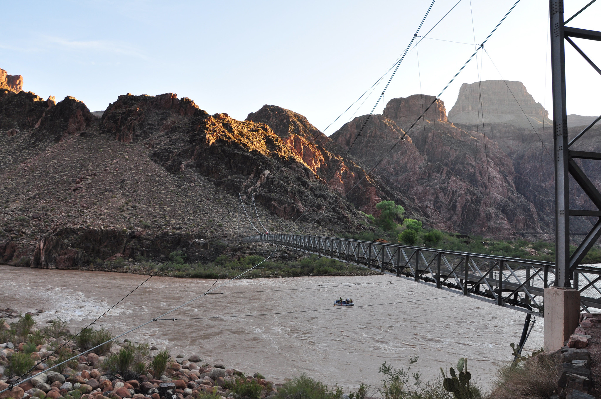 Boaters on the Colorado River pass under the Silver Bridge while getting an early start on their day's journey. NPS Photo by Erin Whittaker.