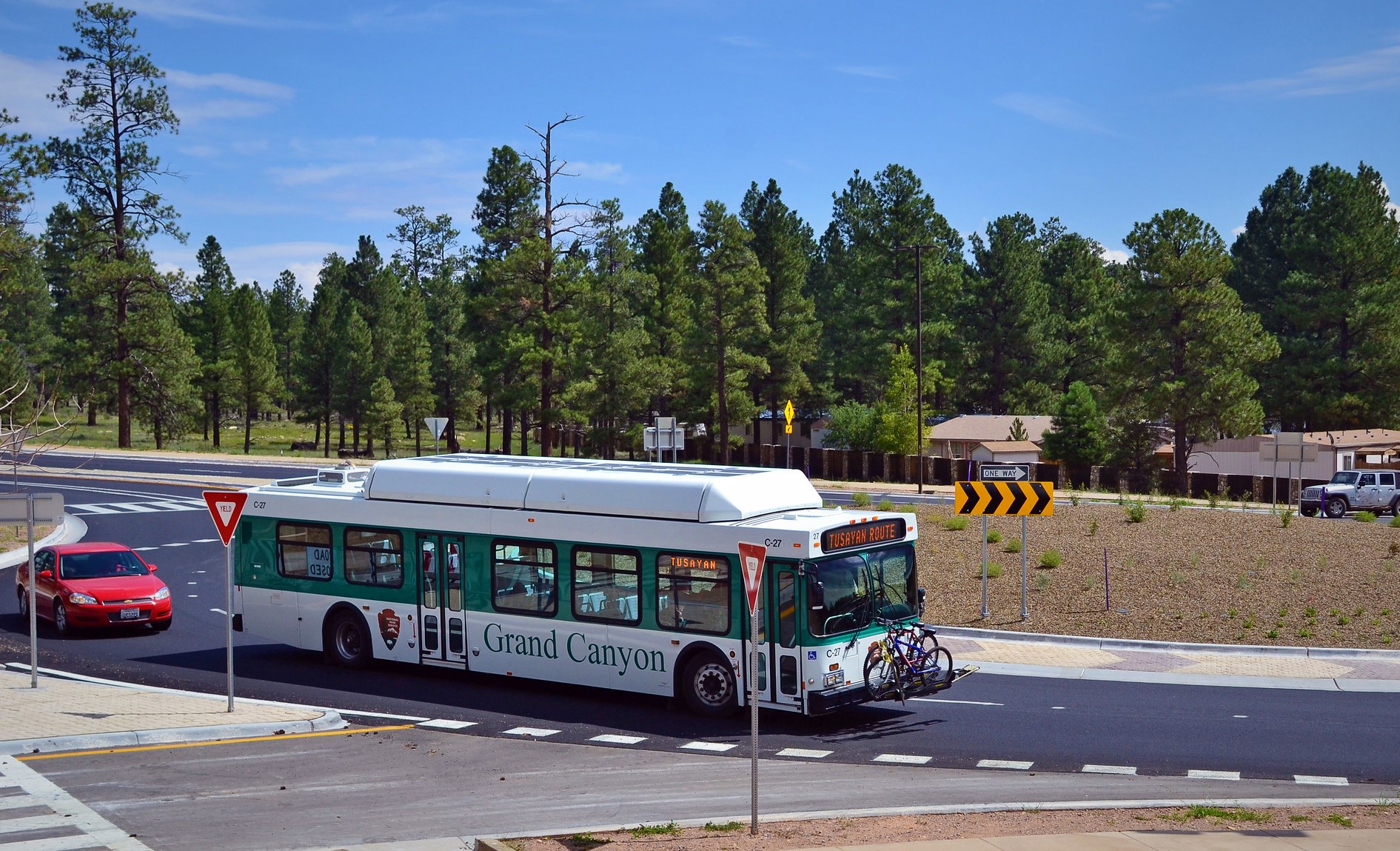 A Tusayan shuttle bus drives around a roundabout in Tusayan