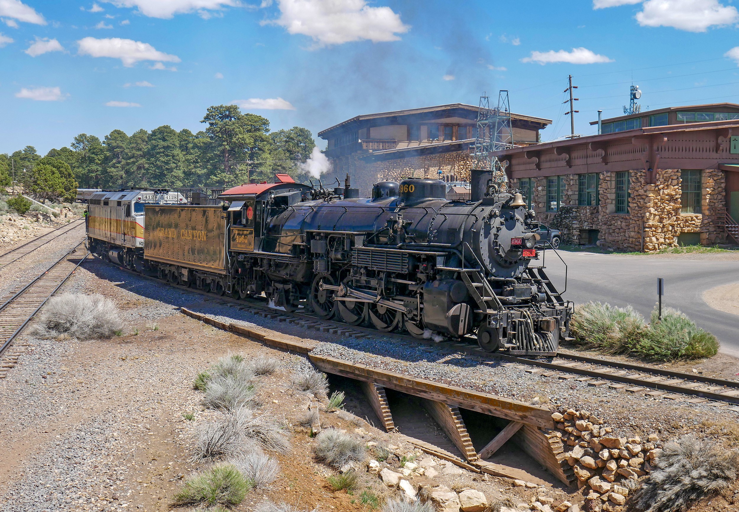 A train passes over the wooden ballast bridge over Bright Angel Wash