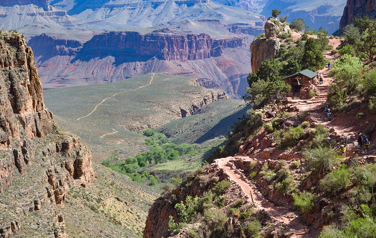 Image of the Three-Mile Resthouse with a vast canyon landscape in the background