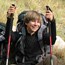 A woman hiker holding hiking poles in each hand.