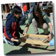 child and ranger using screen to sift artifacts from soil