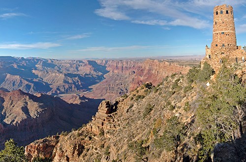 Stone tower overlooks the canyon with flat desert to the right.