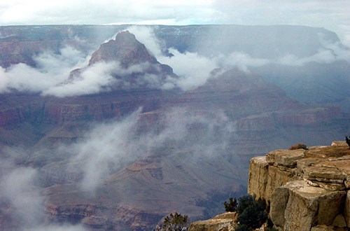 Rock formations surrounded by fog and low clouds.