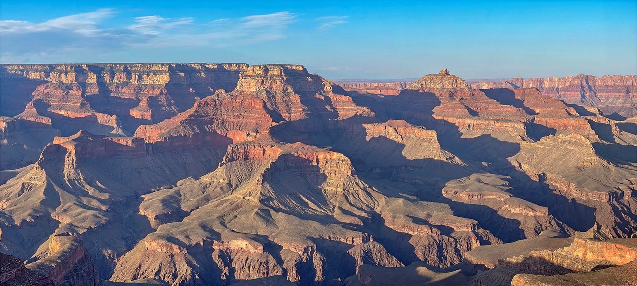 nearing sunset, colorful peaks and cliffs create complex shadow patterns within a mile deep canyon landscape.