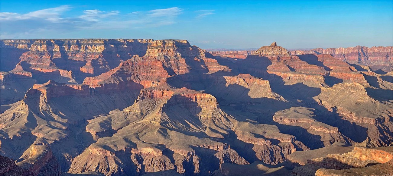 nearing sunset, colorful peaks and cliffs create complex shadow patterns within a mile deep canyon landscape.