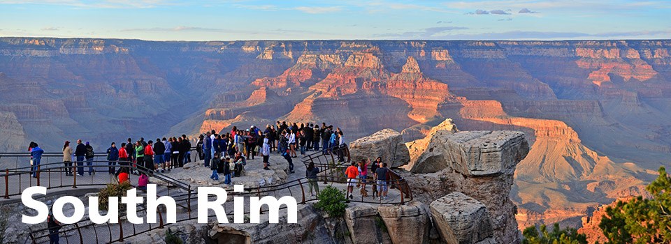 A crowd of people on Mather Point at sunset.