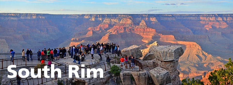 A crowd of people on Mather Point at sunset.
