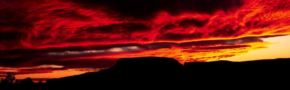 A bright red and orange sunset at the canyon.