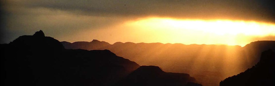 The sun comes up above the canyon at sunrise.