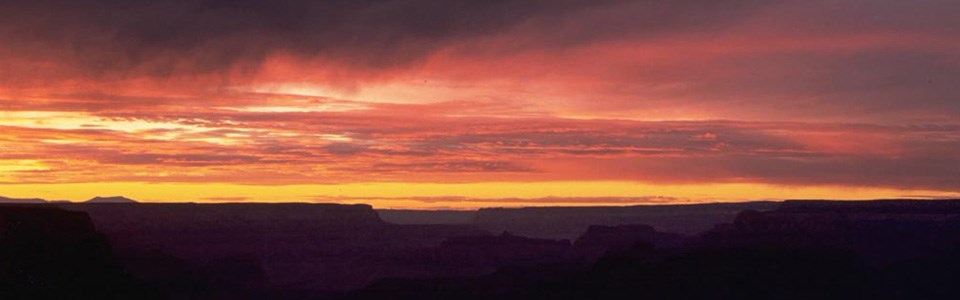 Pink and orange skies over the canyon during sunset.