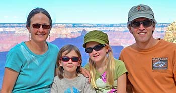 family of 4 with 2 girls in between parents, grand canyon in background