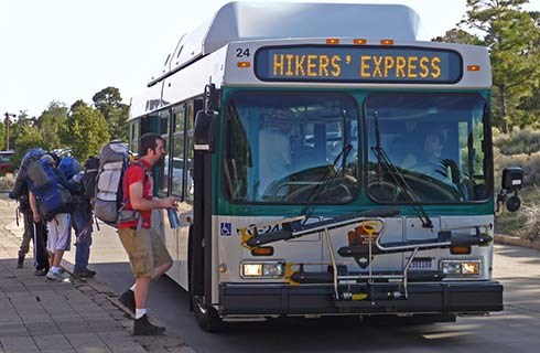 Man wearing red shit and backpack boarding Hiker Express Shuttle at Backcountry Information Center. Man wearing red shit and backpack boarding Hiker Express Shuttle at Backcountry Information Center.