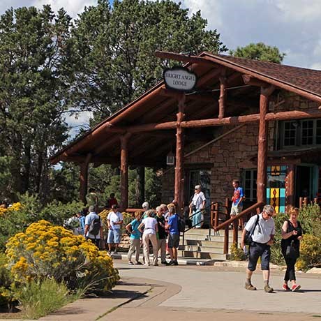 Front entrance to rustic Bright Angel Lodge. Yellow fall colors. People in front. Front entrance to rustic Bright Angel Lodge. Yellow fall colors. People in front.