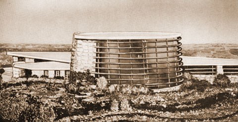 Artist's drawing of original design for chapel, a circular structure of three stories with windows spanning 180 degrees of the circumference, with a stone wall on the other half. A single-story wing is located behind the chapel.