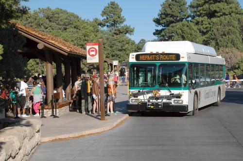 People lined up at a front-facing bus.