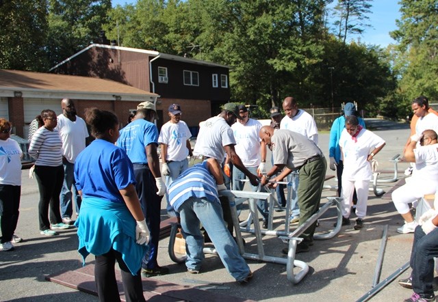 a group of volunteers learning how to put together a table