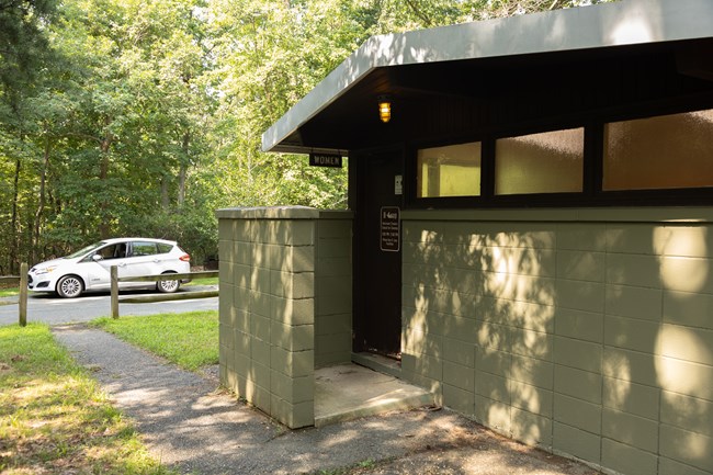 A paved pathway leads to the women's side of a comfort station