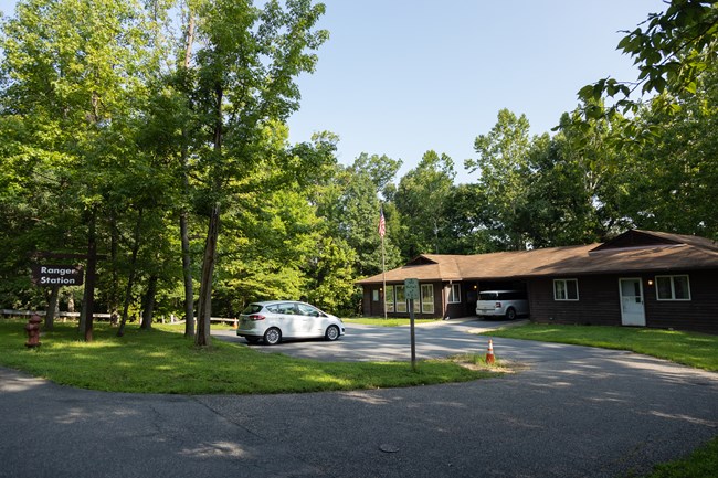 A white car is parked in front of a ranger station