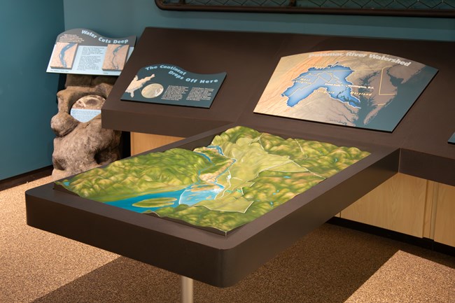 A tactile map of a river valley on a table with panels of text and photos.