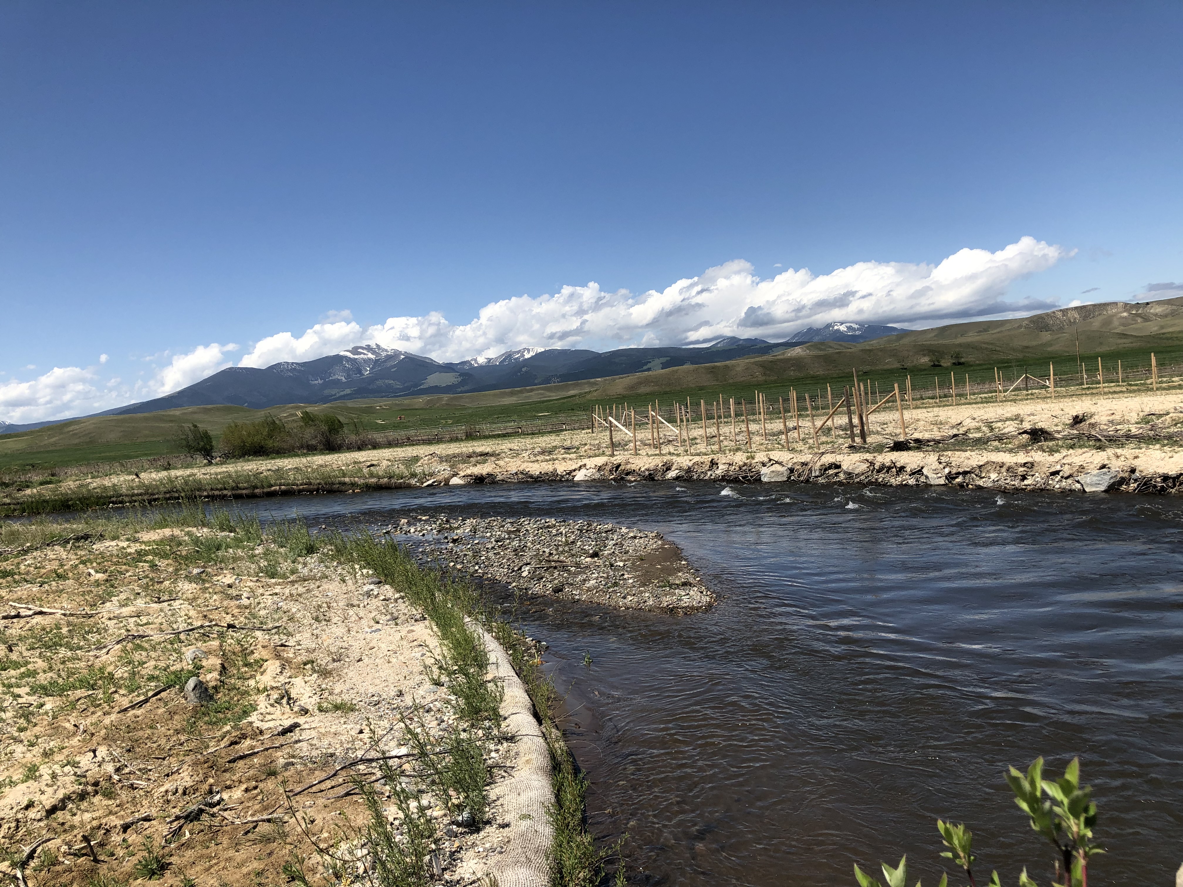 park ranger on left holds a cell phone in bracket on post with sign giving instructions