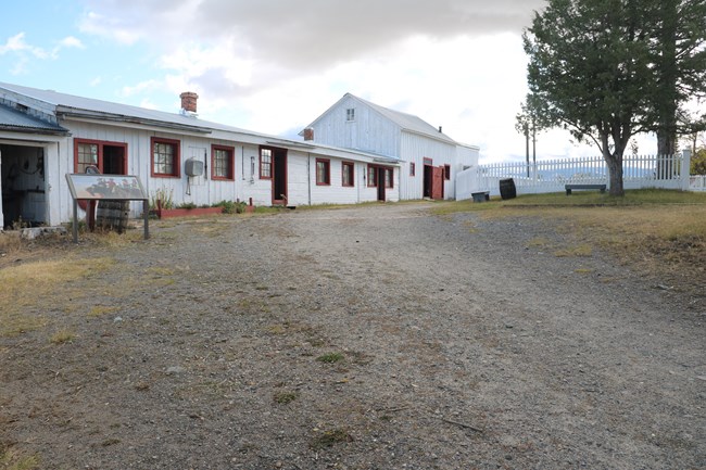 View of slight hill, gravel path in center running back to historic buildings