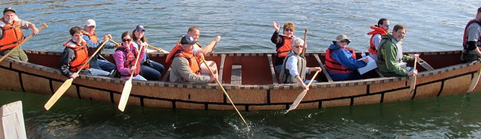 People paddling a large Montreal canoe. People paddling a large Montreal canoe.