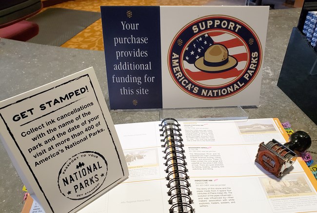 An open NPS passport book and accessories.