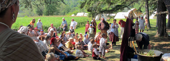 Children and adults watching an outdoor puppet show. Children and adults watching an outdoor puppet show.