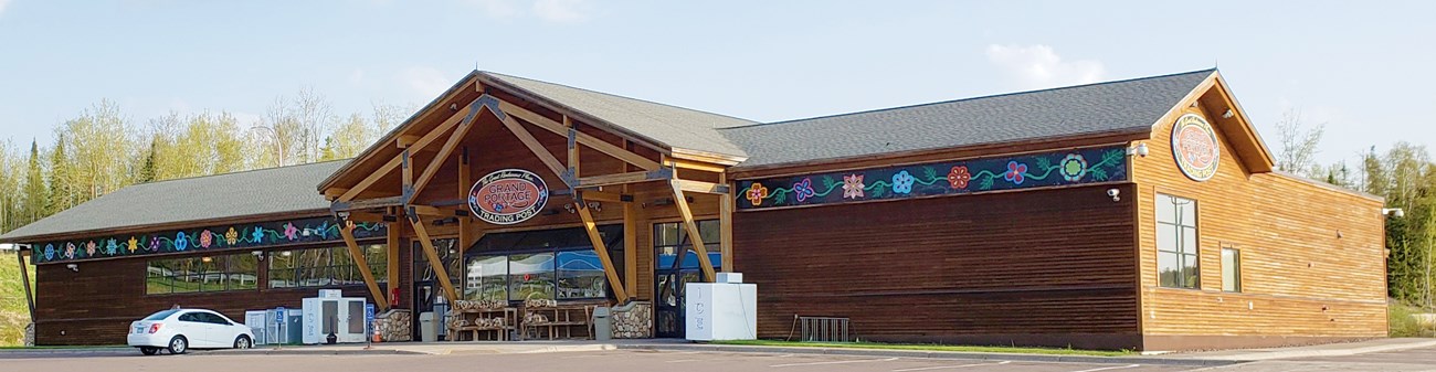 Wooden building decorated with a floral pattern under the eaves with an ice machine in front.