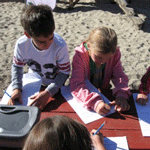 Students explore a simulated archeological dig in their playground.