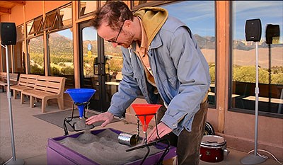 Kevin Larkin playing an original device to make sand music, using funnels and sound equipment