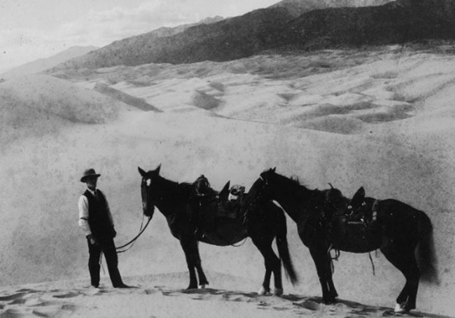 Frank Wellington is pictured with two horses on the Great Sand Dunes in the 1920s