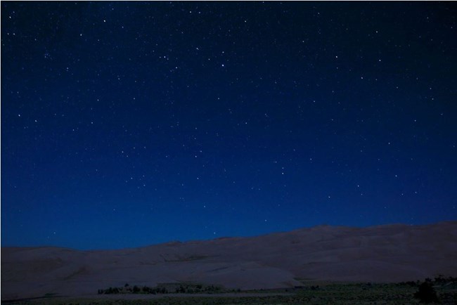 The starry night sky over the Great Sand Dunes