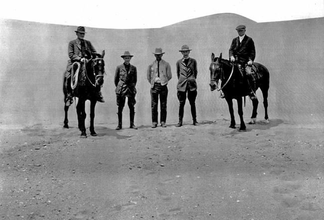 Historical photo of early NPS officials on horseback on the dunes
