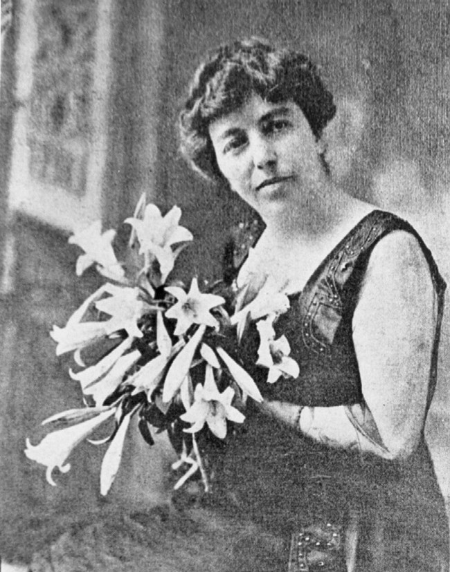 Historic black and white photo of Myrtle Woods holding flowers