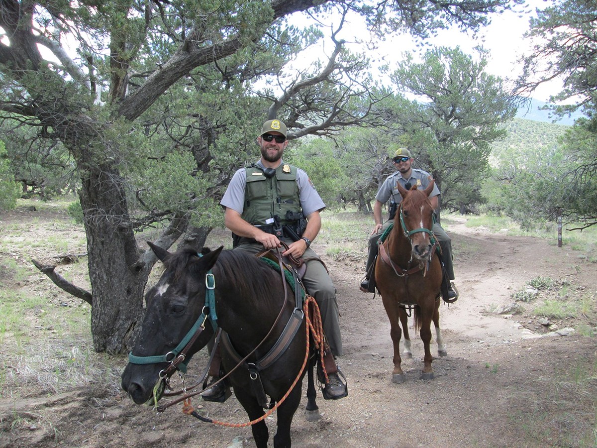 Two park rangers ride horses in the National Preserve