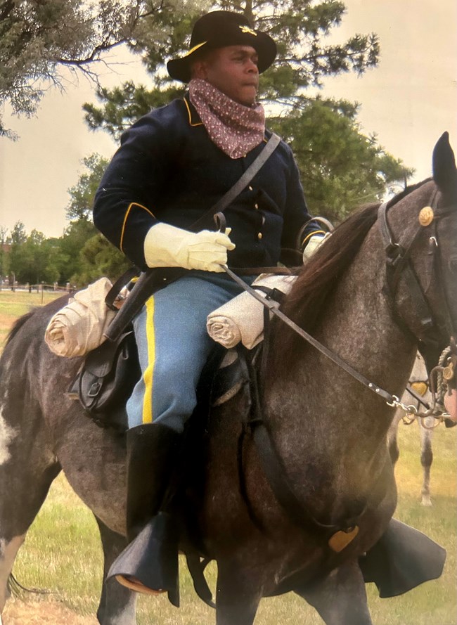 Terrance Beasley reenacts a Black 19th century cavalry soldier riding a horse