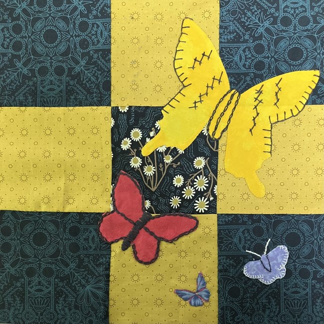 Butterflies stitched onto a quilt block.
