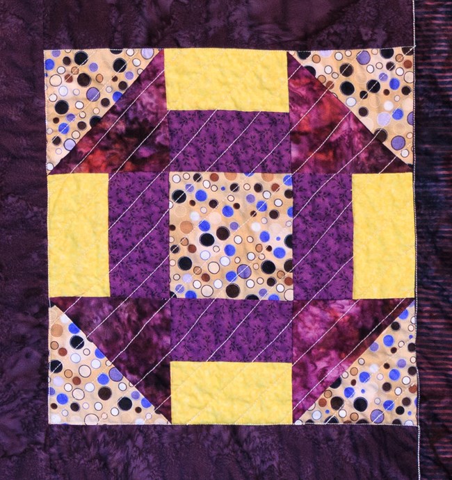 A quilt patch in yellow and purple.
