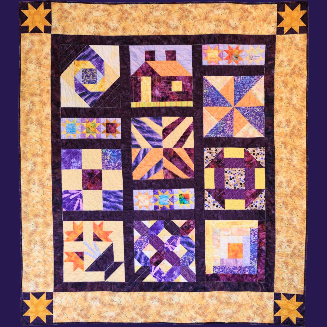 A mostly purple and yellow patterned quilt.