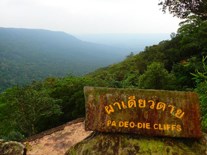 A misty mountain scene with a sign in the foreground that says Pa Deo-Die Cliffs.