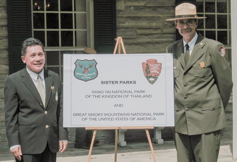 Superintendents of Great Smoky Mountains and Khao Yai National Parks pose for a picture with a sign representing both parks. Superintendents of Great Smoky Mountains and Khao Yai National Parks pose for a picture with a sign representing both parks.