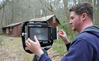 James slides a large negative into the camera.