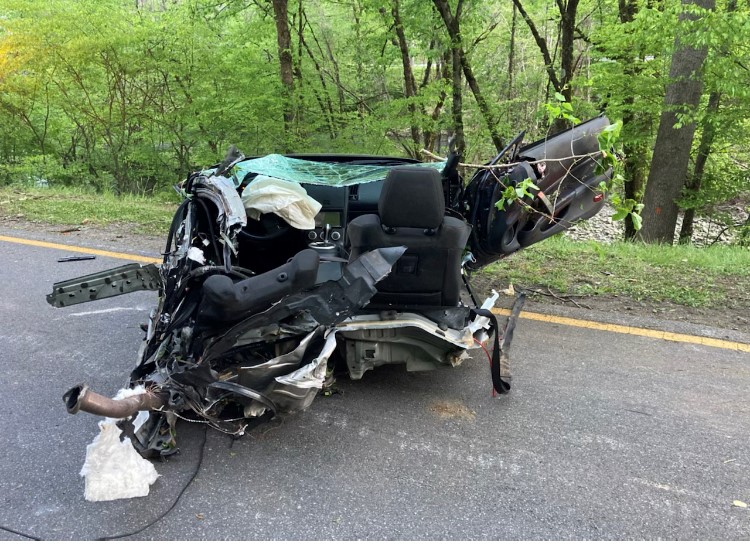 Roadside with severely damaged vehicle.