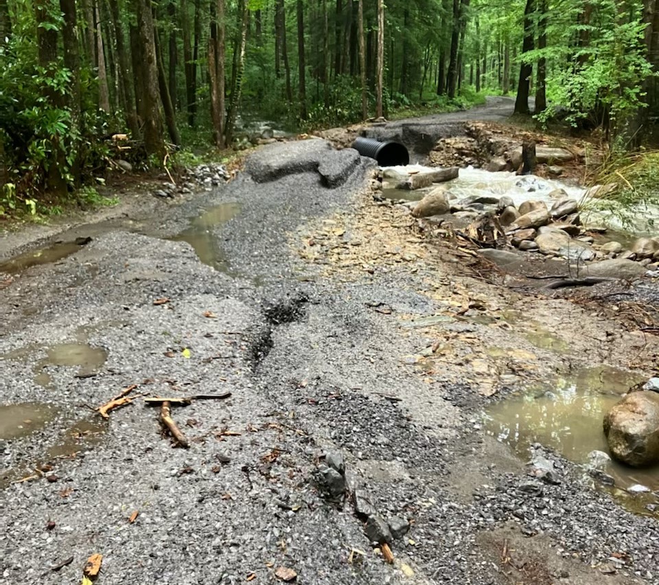 Porters Creek Road washout before culvert A gravel road in two sections with water and broken pavement and a culvert between pieces
