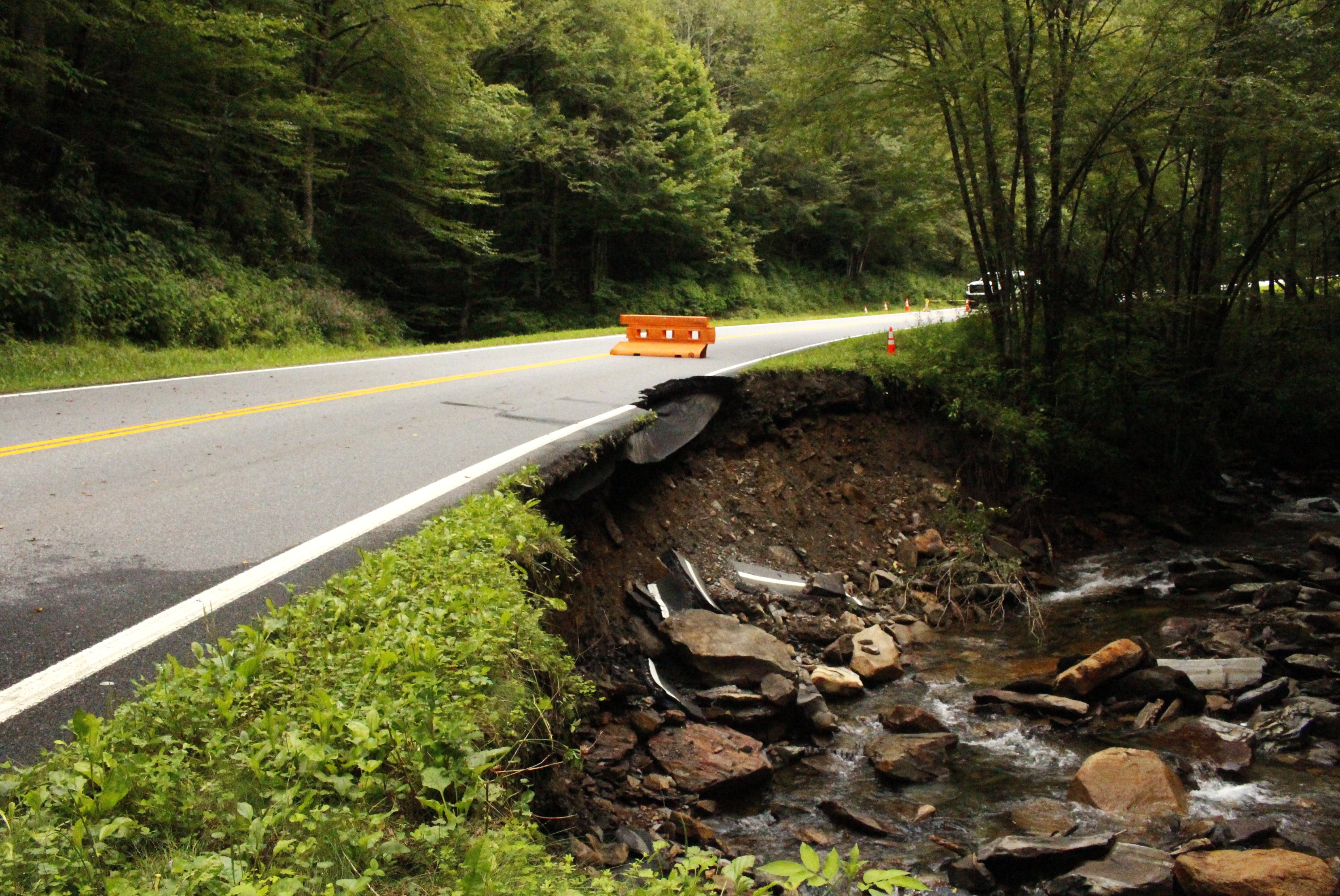 A damaged roadway along a stream