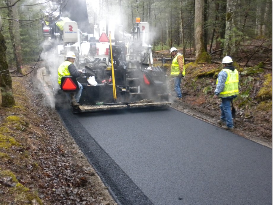 Cades Cove Loop Road Paving Project Workers paving a narrow road through the forest.